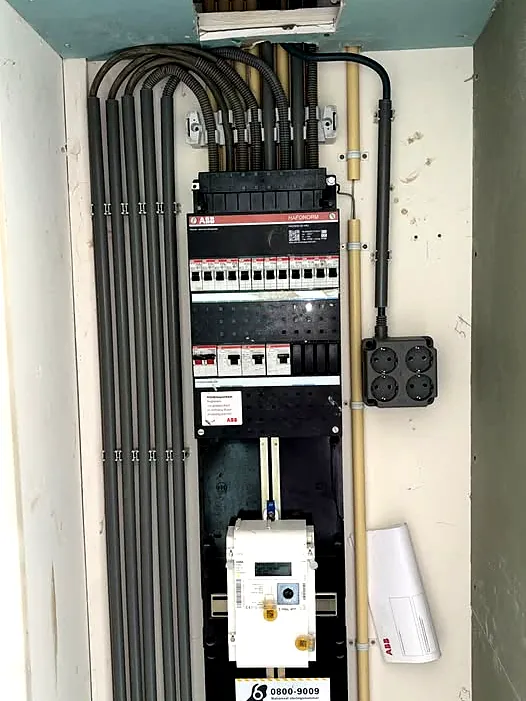 Nieuwe groepenkast met ABB-aardlekautomaten, netjes ingevoerde bedrading en de slimme meter eronder